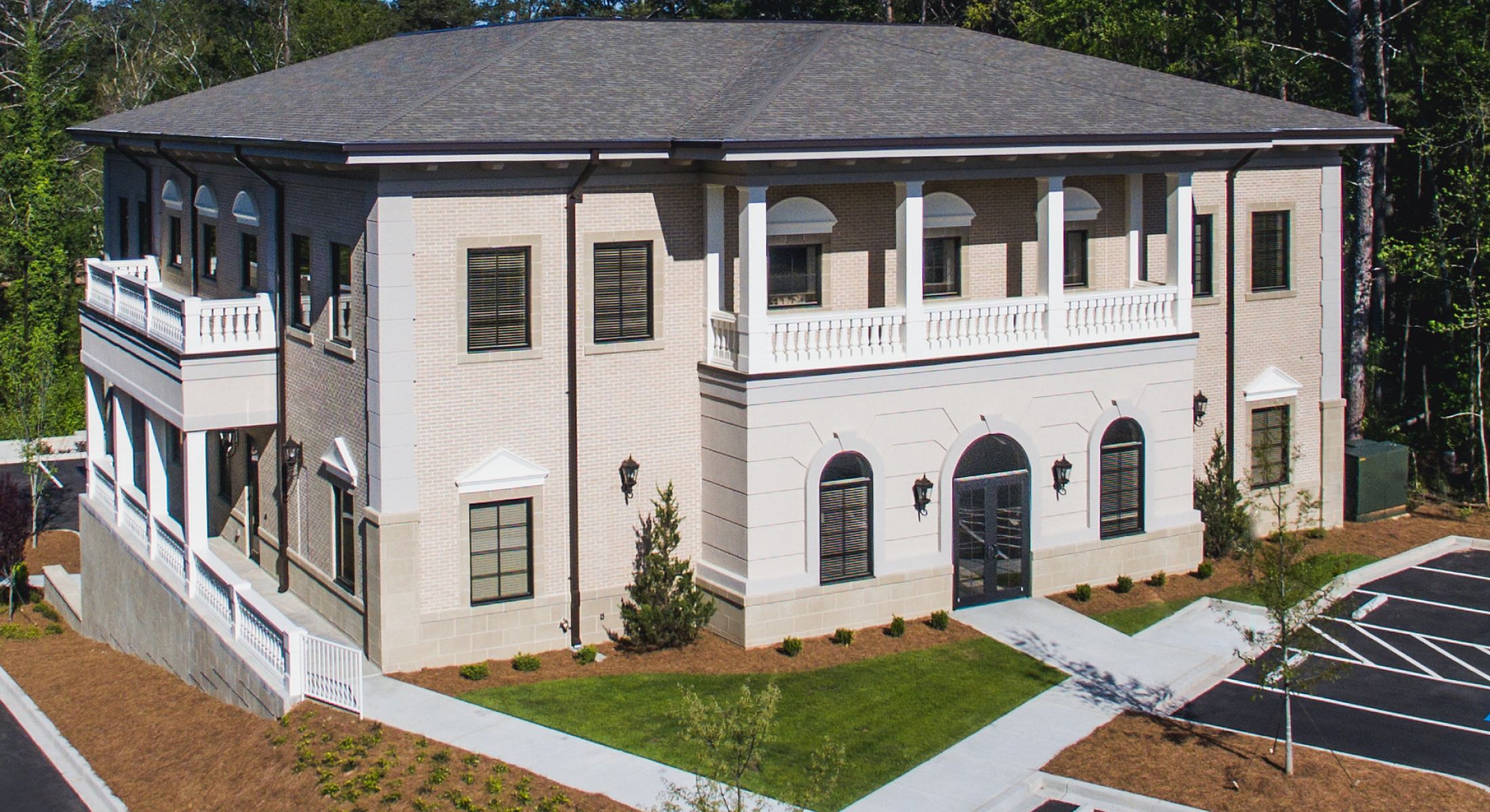 Modern building with landscaping and parking area.